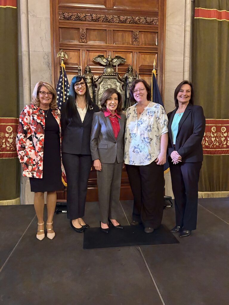 Women leaders and professionals gathered in a government chamber highlighting women in skilled trades and workforce development